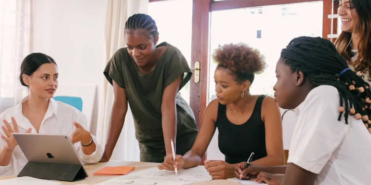 A group of UX designers gathered around a table, discussing how to design for new tech