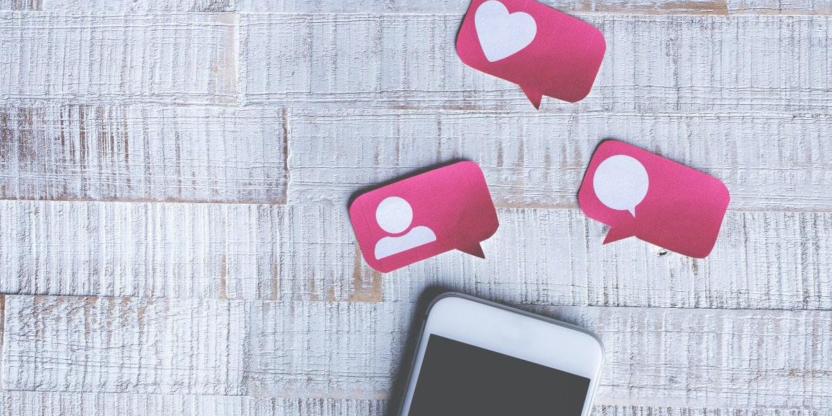 A phone on a tabletop with three paper cutout notificationsRemote UX designers