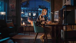 young ux designer working remotely at a desk late at night