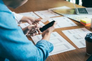 UX designers work at a table with papers on it in a remote office