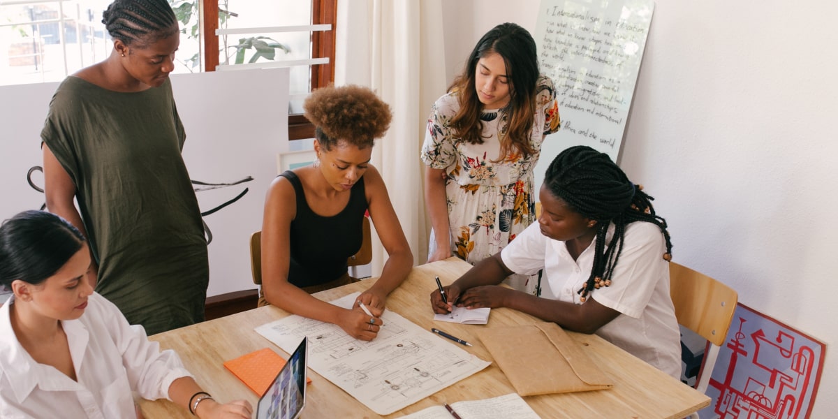 A diverse group of designers gathered around a table discussing inclusive design approaches