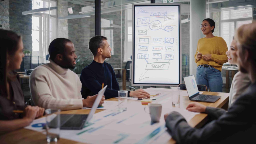 a ui designer standing hows a plan to a team of designers sitting down