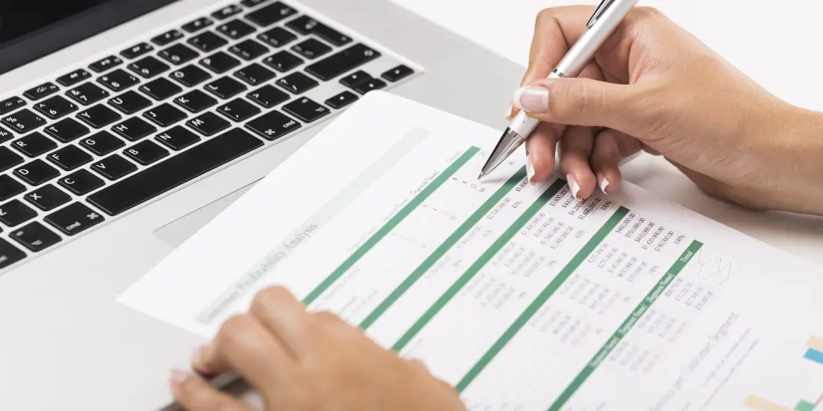 A data analyst looking at a print-out of data from an Excel file