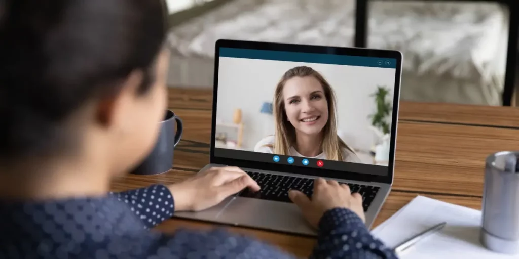 A digital marketing degree student talking to their mentor via video call on a laptop