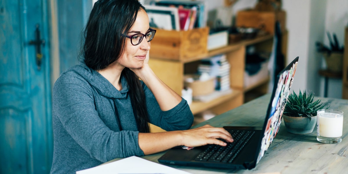 A digital marketing manager in side profile, working on a laptop
