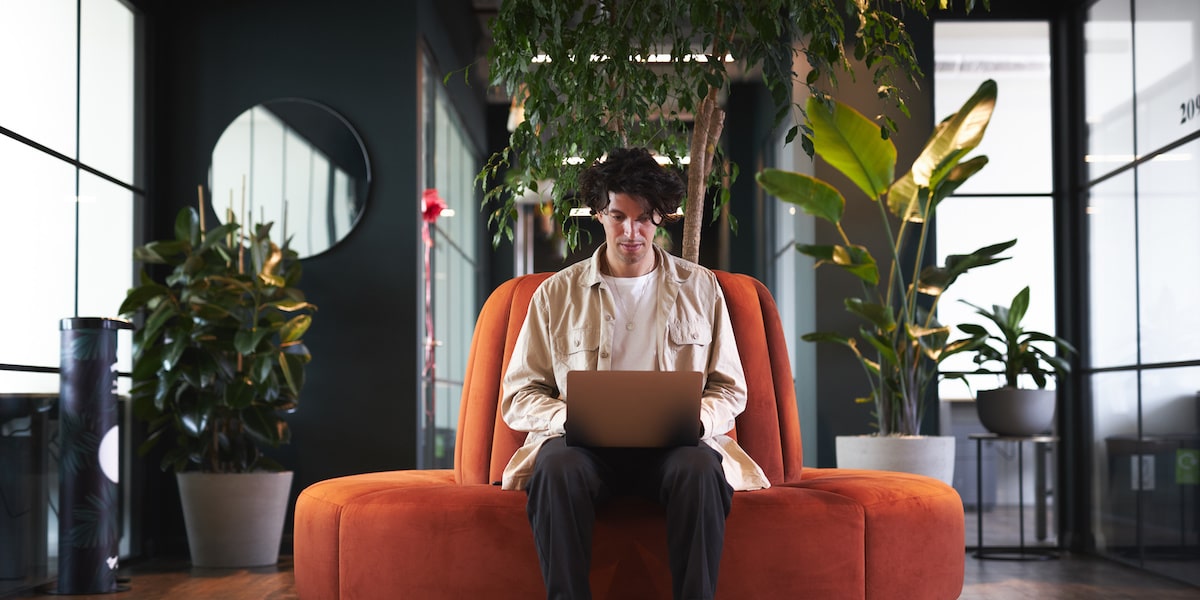 Man works remotely with his laptop working in a recession-proof industry.