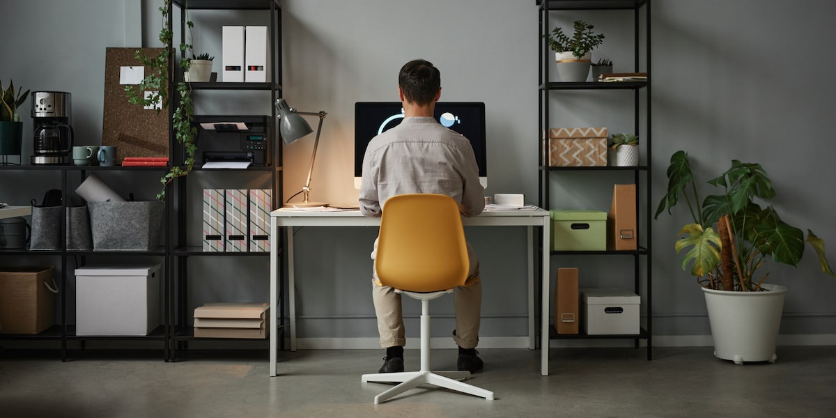 A man taking coding bootcamps with job guarantee in his home office.