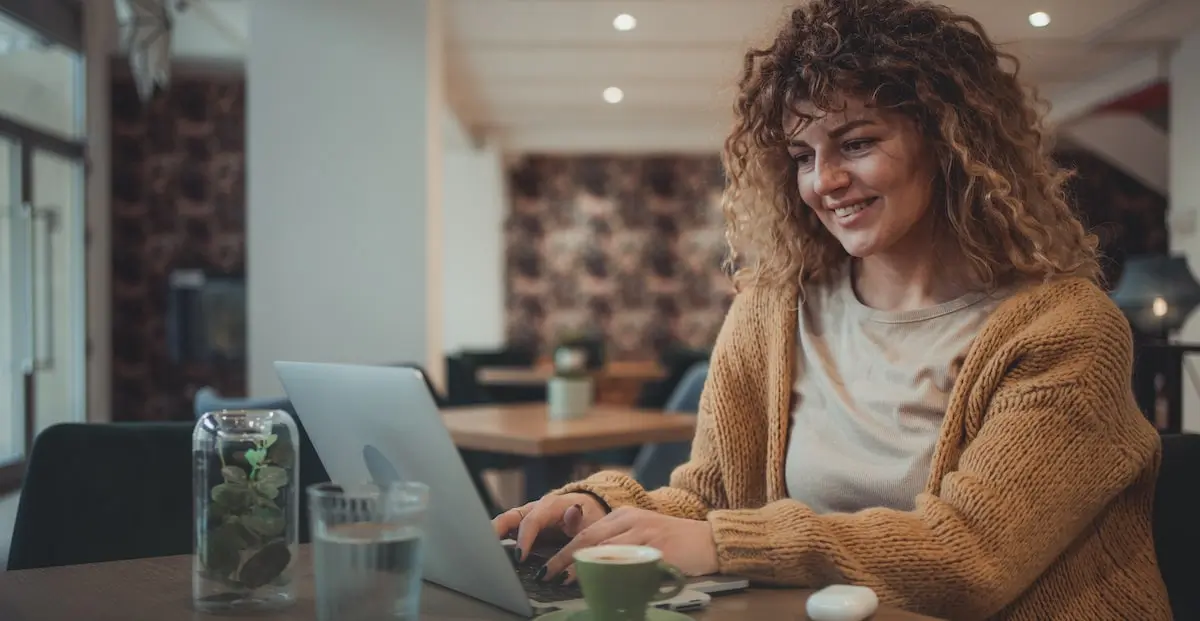 Woman in a cafe taking a coding bootcamp in Berlin remotely.