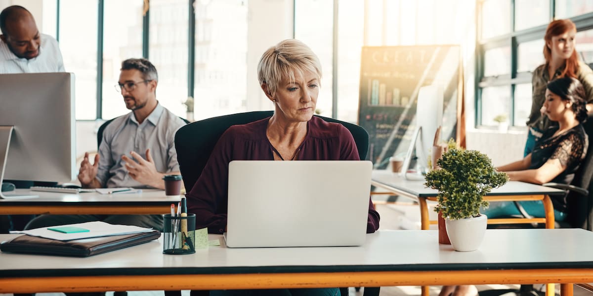 A product manager works in a bright office using AI tools.