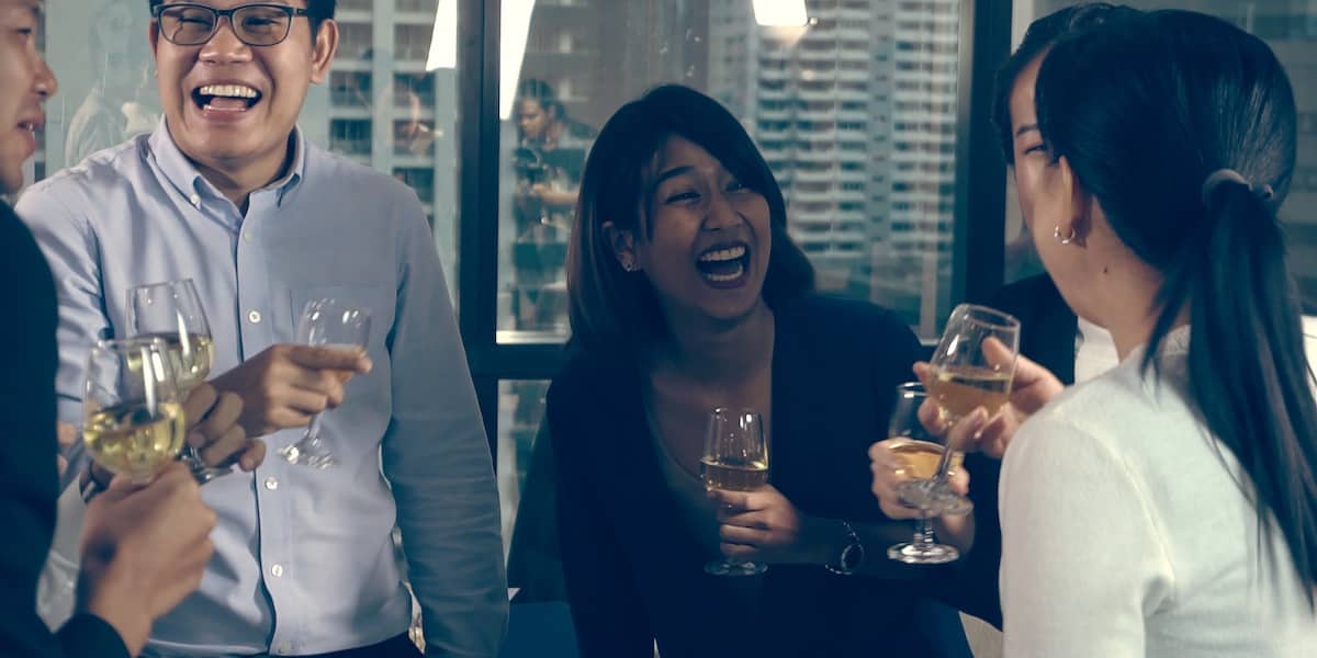 A team with glasses of liquid celebrating a product launch.