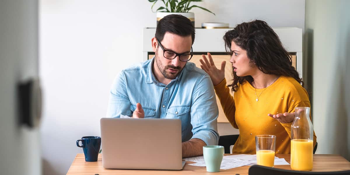 A man and a woman arguing over a laptop computer.