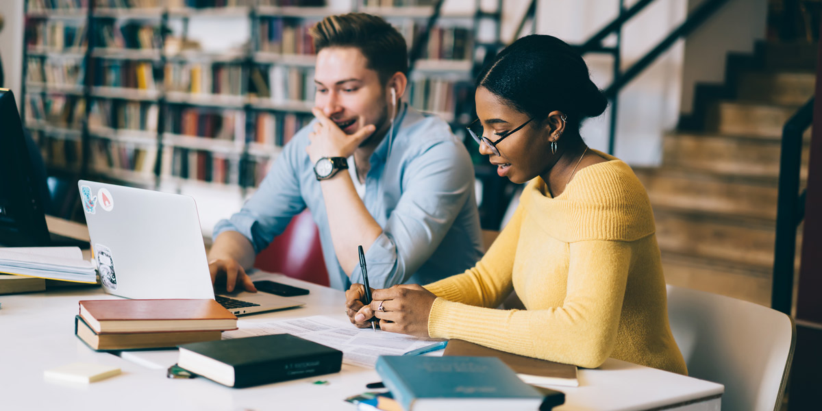 UX Trends 2021: Behavior Research Two UX professionals sitting at a desk, reviewing research findings