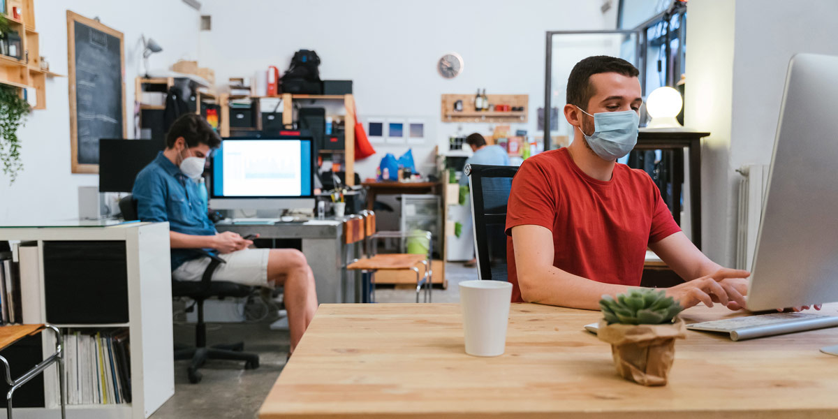 UX designers social distancing in an office, and wearing masks