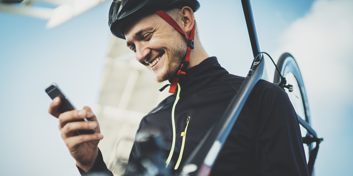 UX Trends 2021: Personalization A person carrying a bike, looking at their phone and smiling