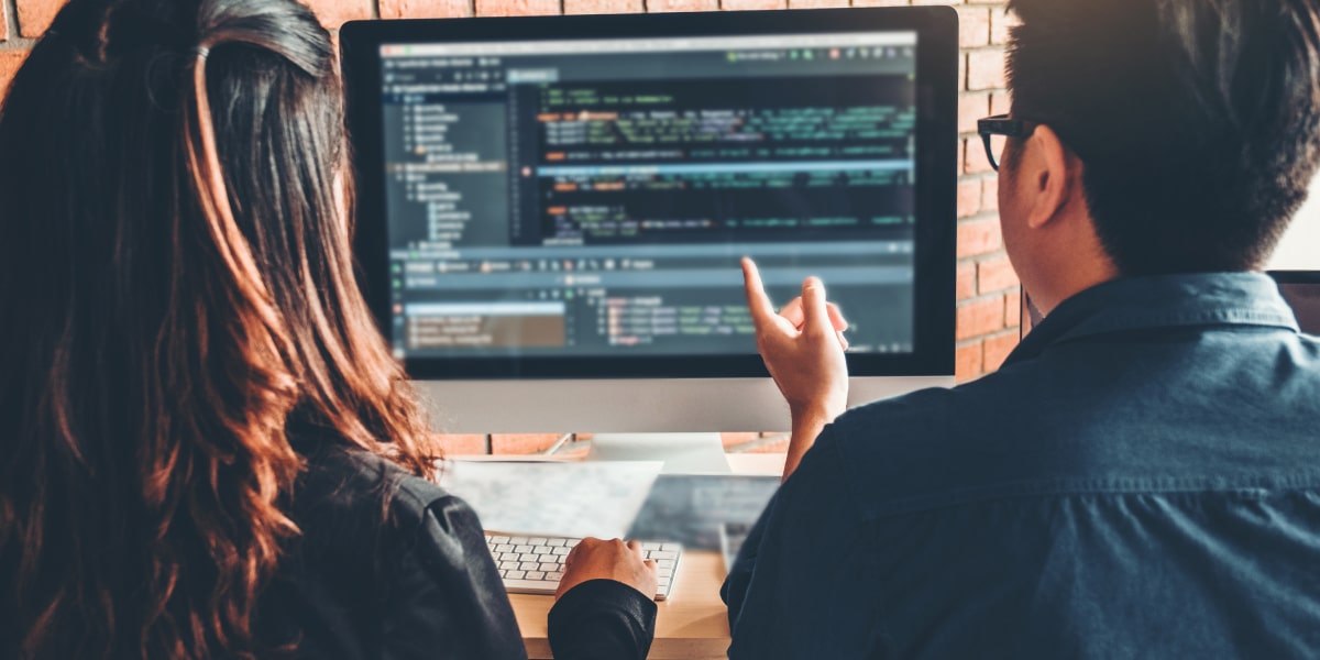 A web developer and their mentor looking over some code on a screen