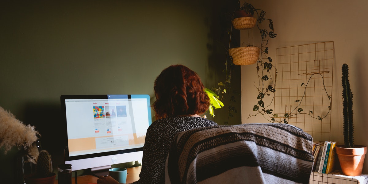 Woman sitting at home on a desktop computer learning with a free coding tutorial