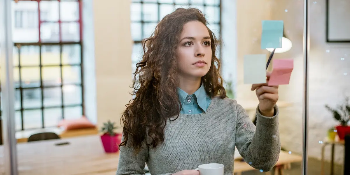 UX designer working at a board with sticky notes.