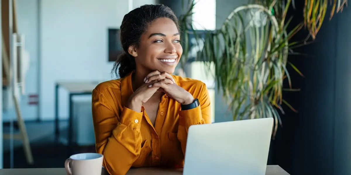 A freelancer worker sits at laptop looking satisfied after coming to terms with freelancer disadvantages