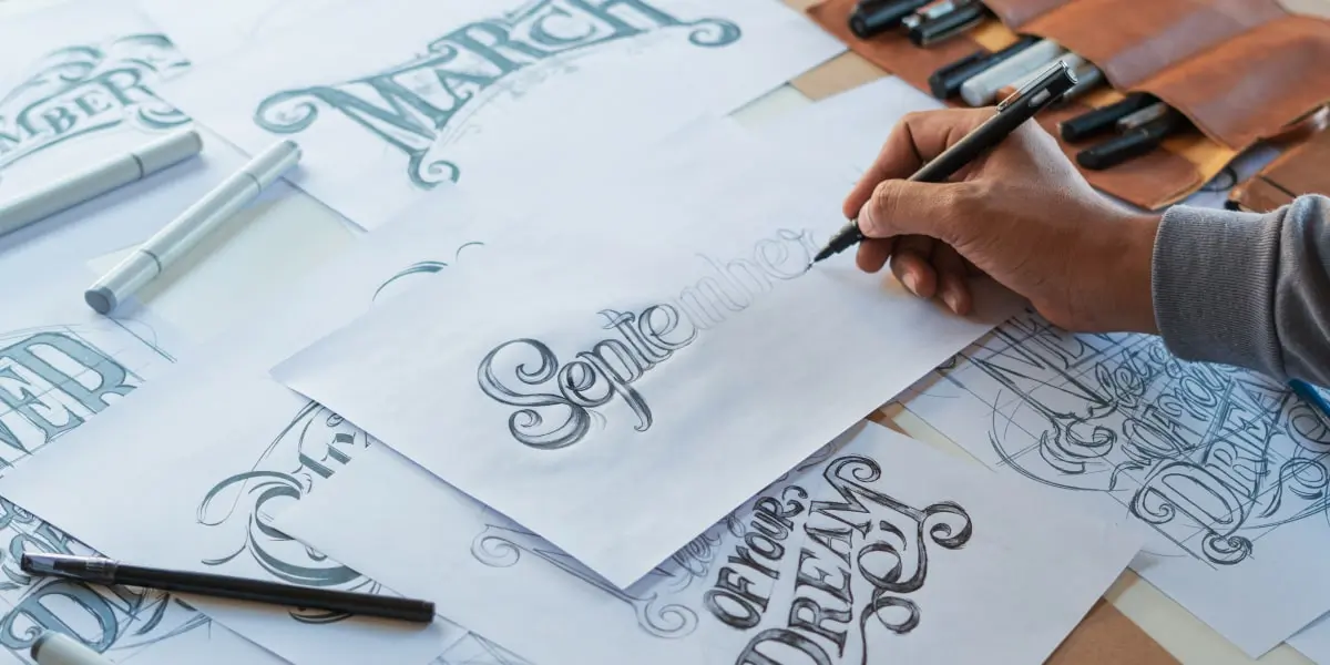 A designer hand-drawing different typography styles