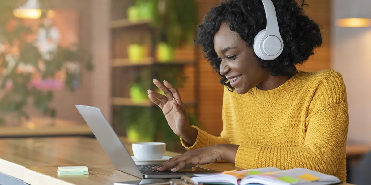 A data analytics student wearing headphones, working on a laptop