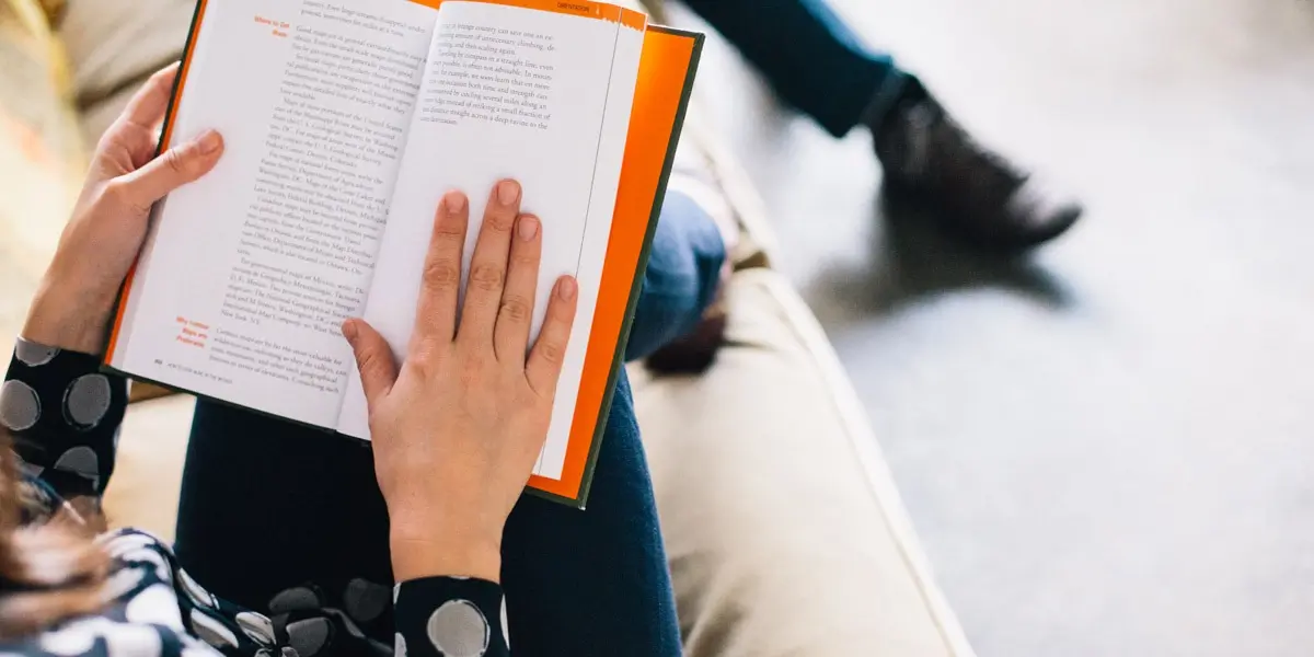 A designer's hands, holding a book