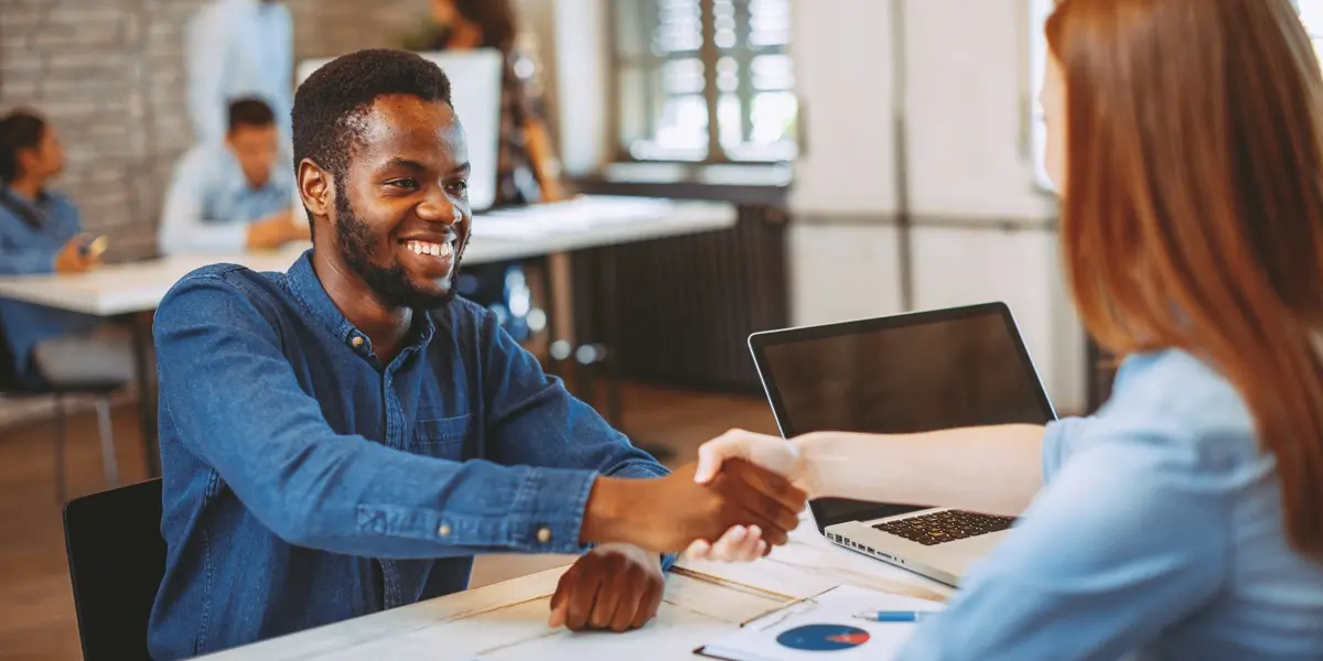 A candidate shaking hands with a hiring manager during an interview