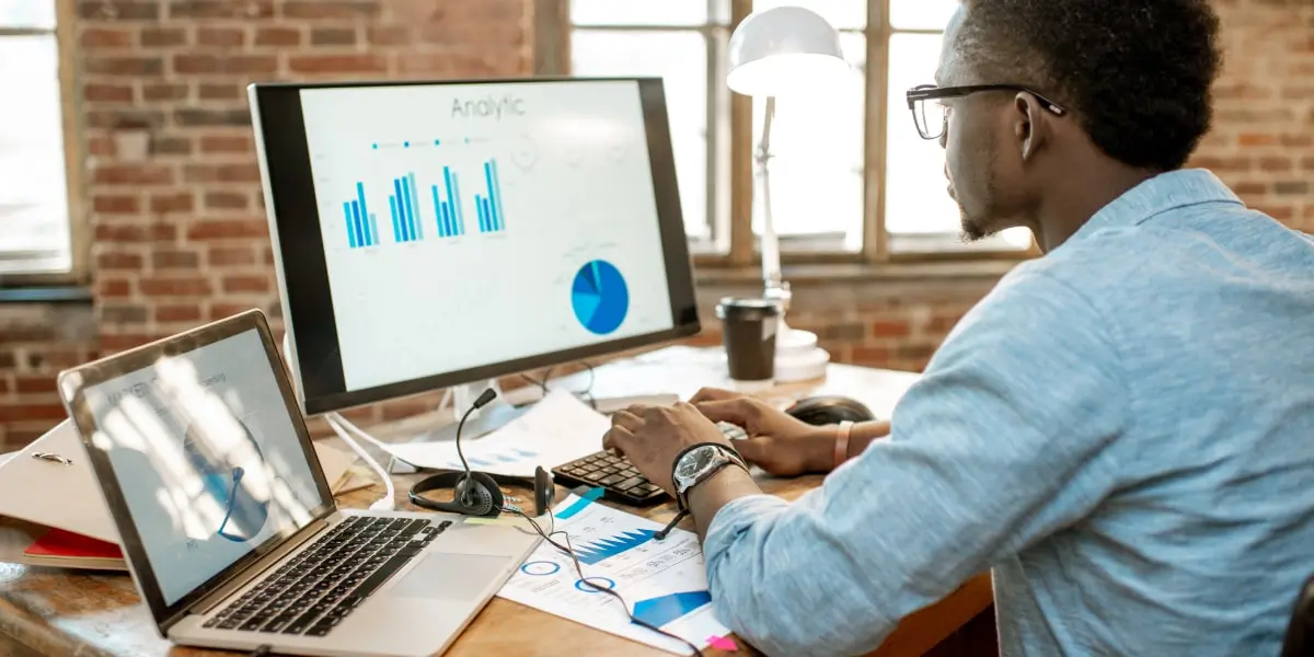 A data analyst looking at data visualizations on a computer