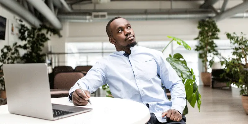 Designer sitting at a desk in an office, staring off thoughtfully