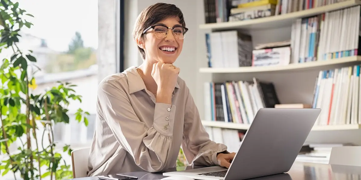 A data analyst sitting at a desk, smiling