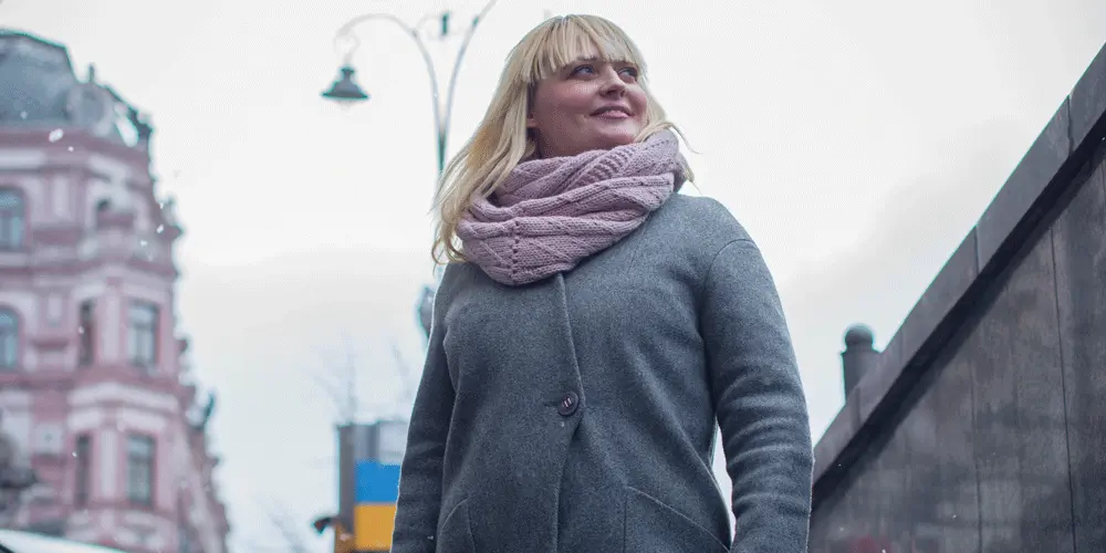 An aspiring UX designer standing in the street, smiling