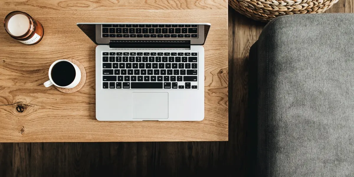 An open laptop and a coffee cup on a table