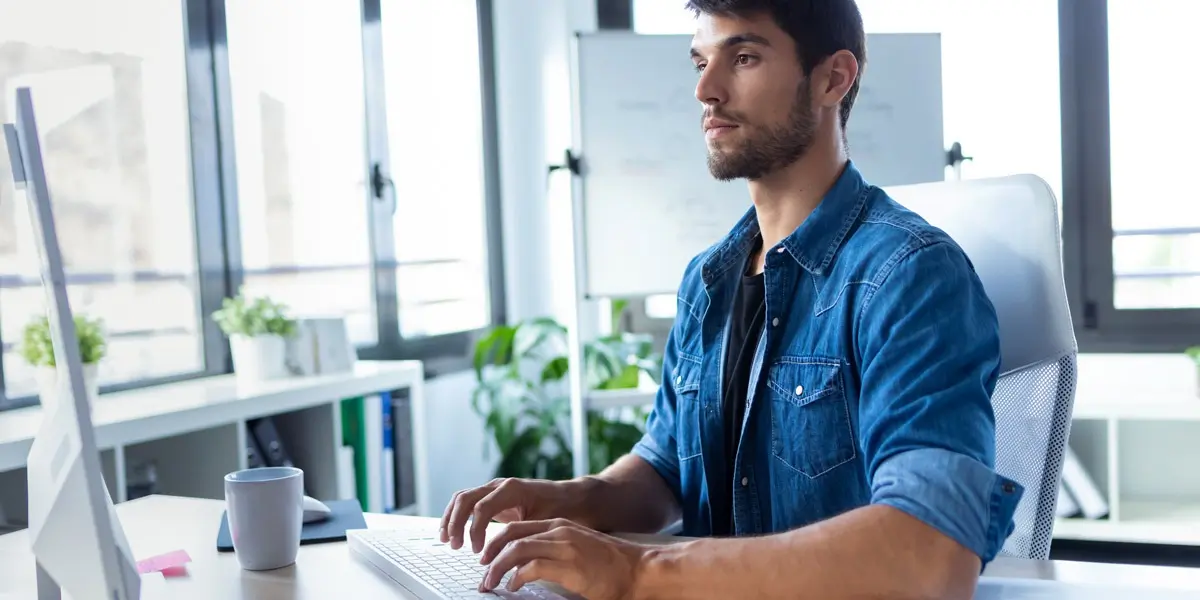 A data analyst typing on a laptop keyboard