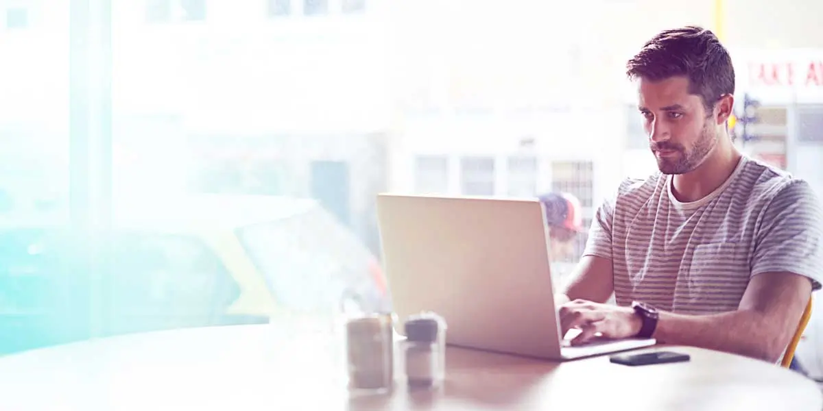 A web developer sitting at a desk with his laptop