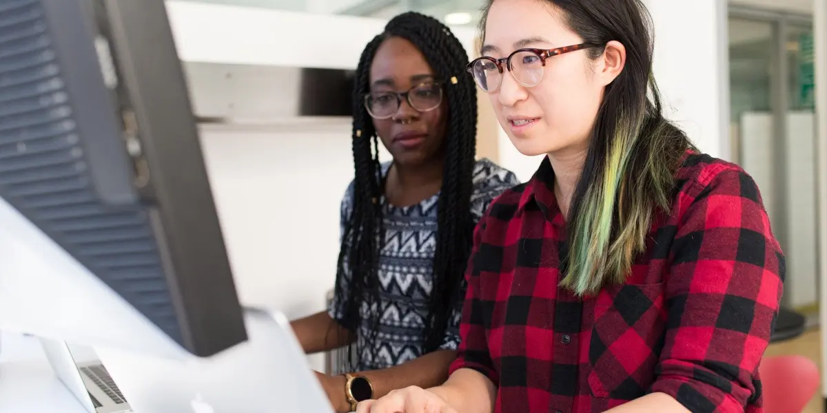 Two digital designers in side profile, looking at a computer screen