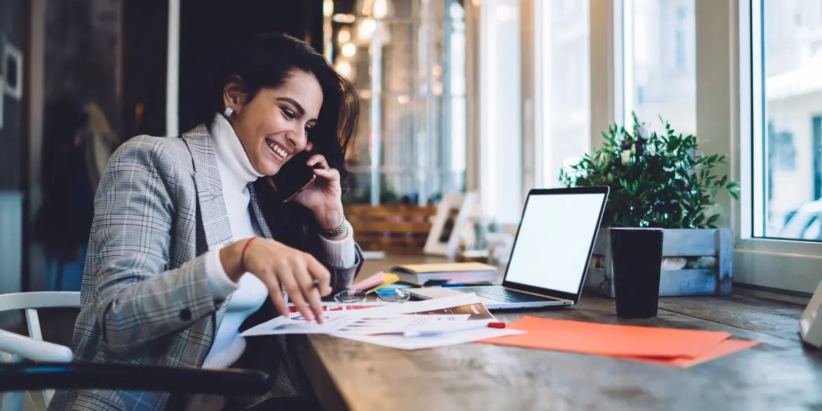 An aspiring designer sitting at a desk, talking on the phone