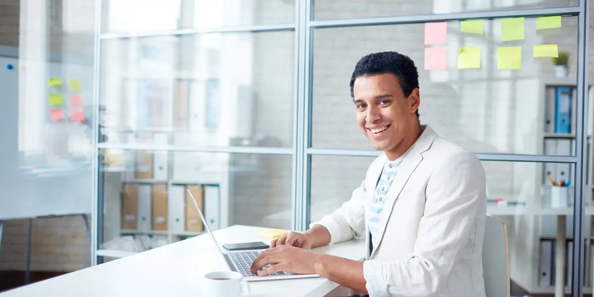 A designer sitting in a bright office, smiling