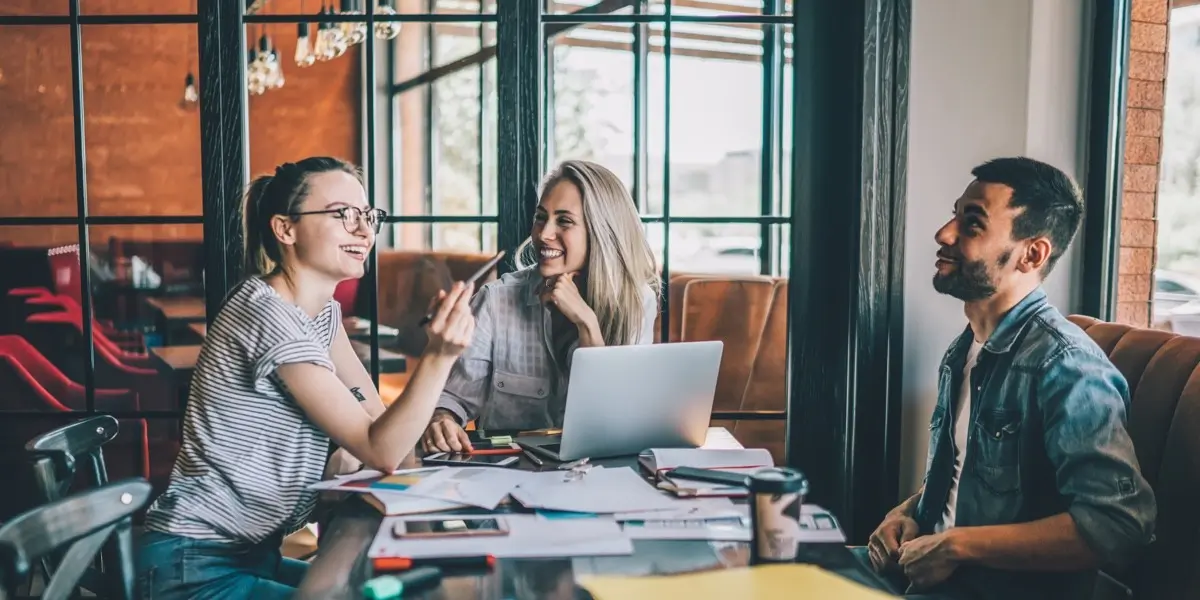 A group of designers sitting around a table in an open plan office