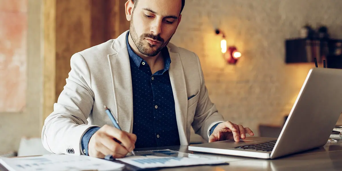 A data analyst sitting at a desk, looking at graphs