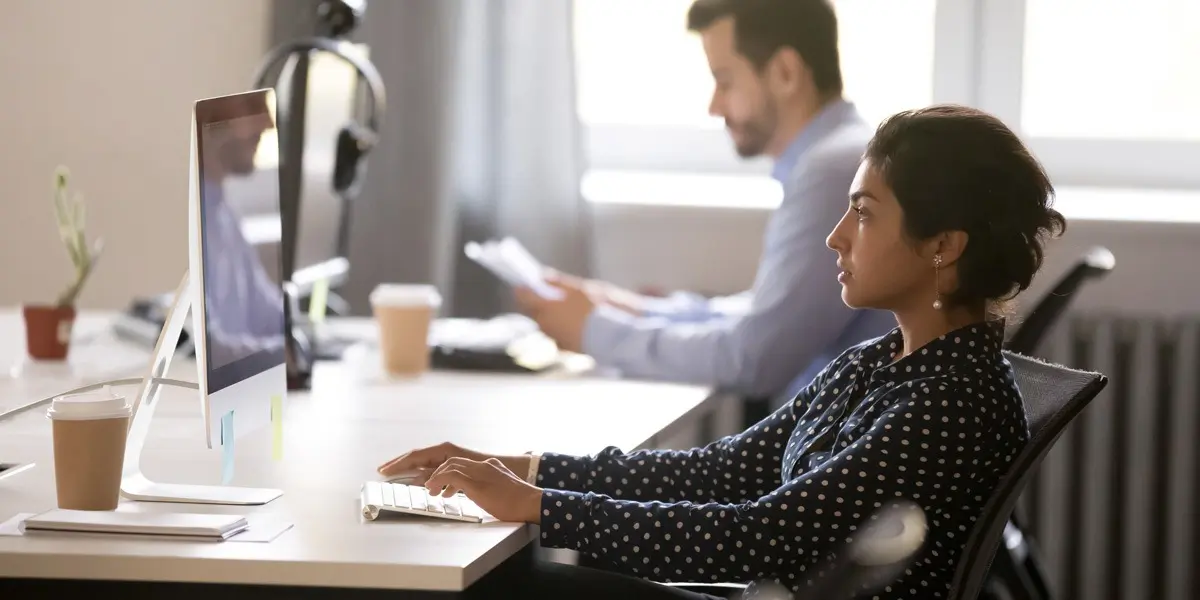 Two data analysts in side profile, working in an office