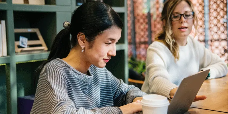 Two designers sitting at a table, looking at the microcopy in their product