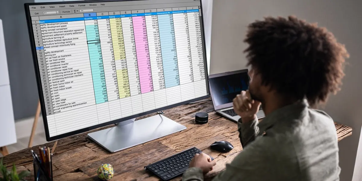 A data analyst looking at a spreadsheet on a computer