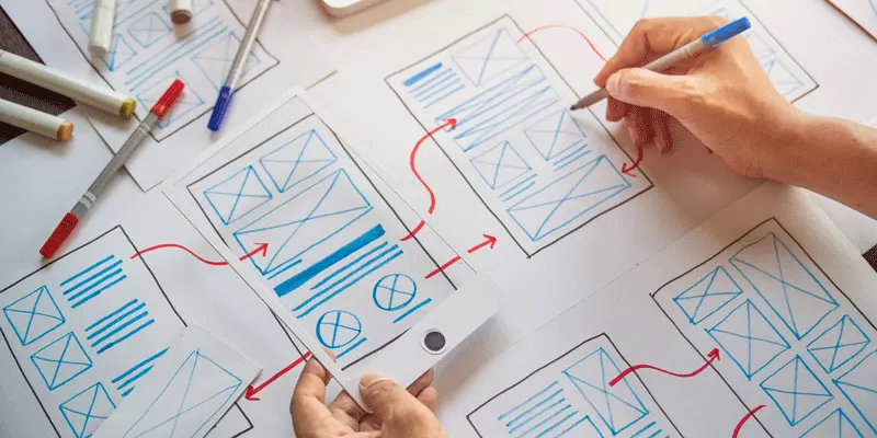 A designer's hands, creating a paper prototype