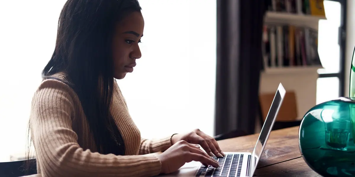 A designer sitting at a table with a laptop