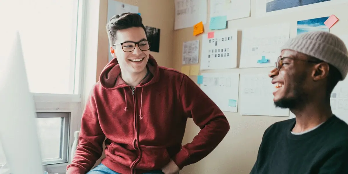 Two UX bootcamp students sitting in a work area, talking about work-life balance