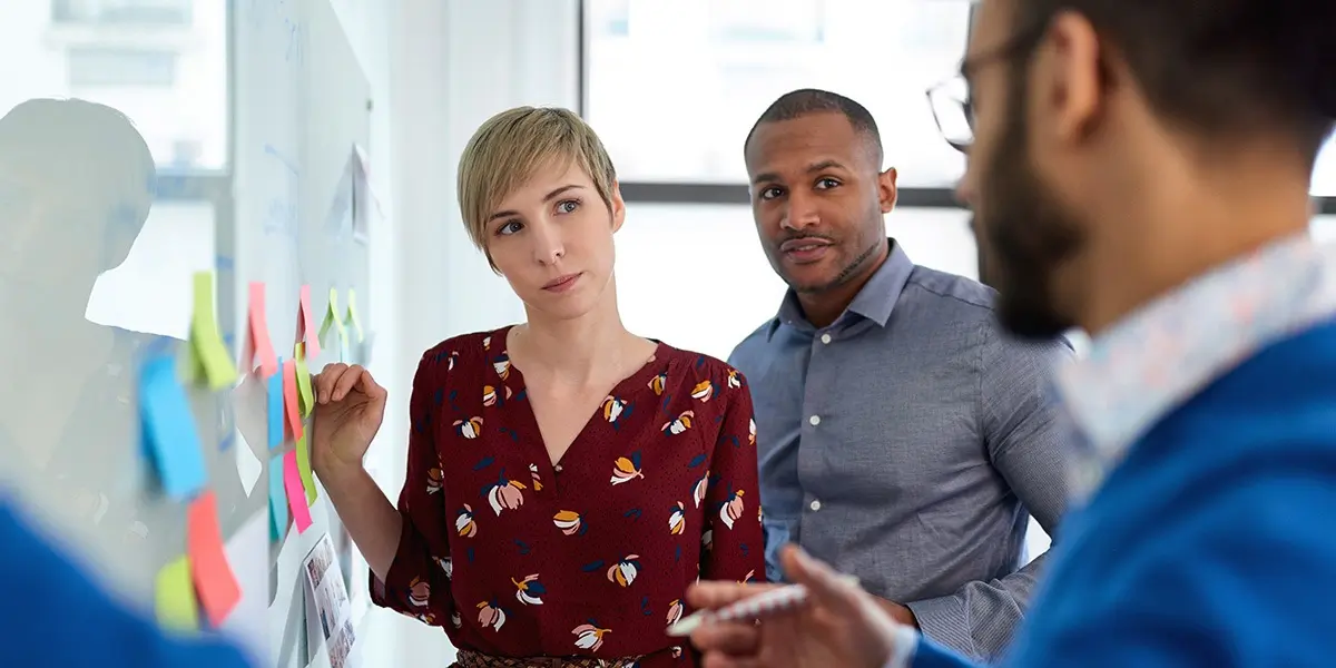 Three designers ideating at a whiteboard