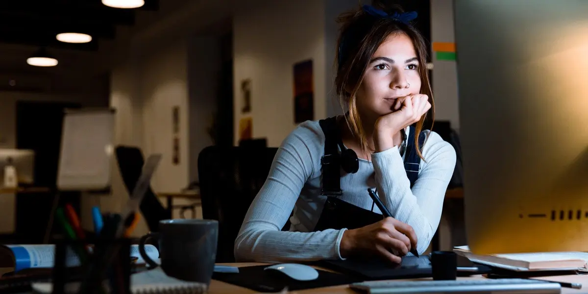 Young woman looks up free UX design training resources and free UX design bootcamps on her computer