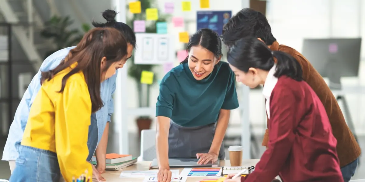 A group of UX designers gathered around a table, working on a project