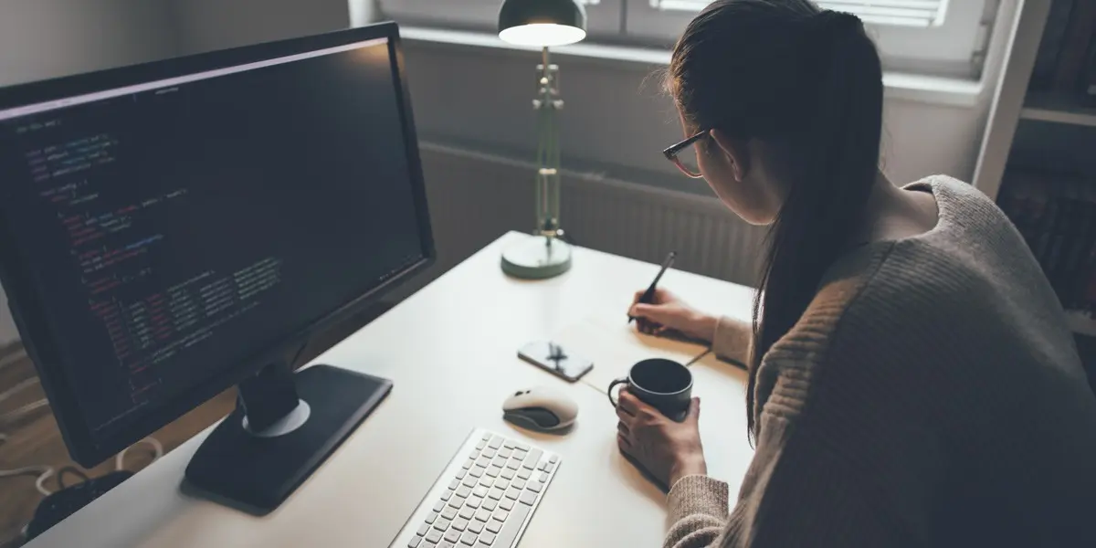 A data analyst sitting at a desk, learning about Python