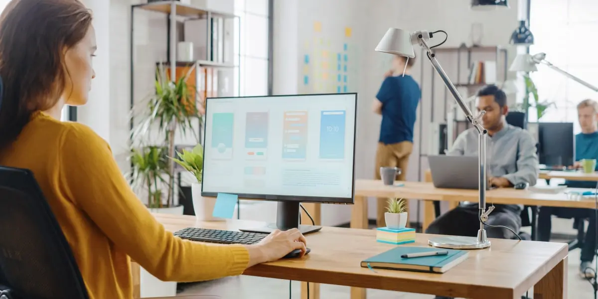 A data analyst in a bright, airy office, working on a computer