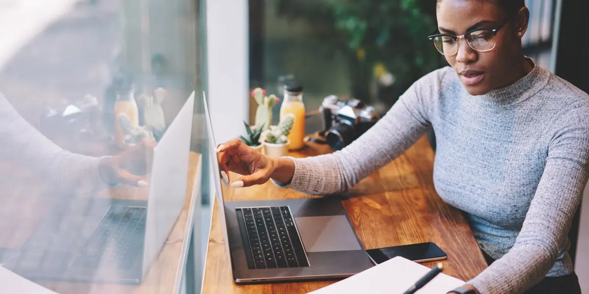 A data analyst sitting at a desk working on a laptop